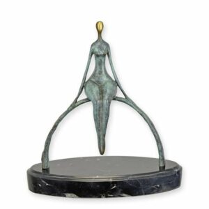 UNE SCULPTURE EN BRONZE D'UN HOMME MODERNE ASSIS SUR UN ARC